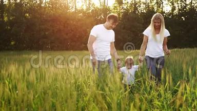 爸爸妈妈和儿子走在田野里，穿着白色T恤和牛仔裤的尖钉，手上挥舞着它